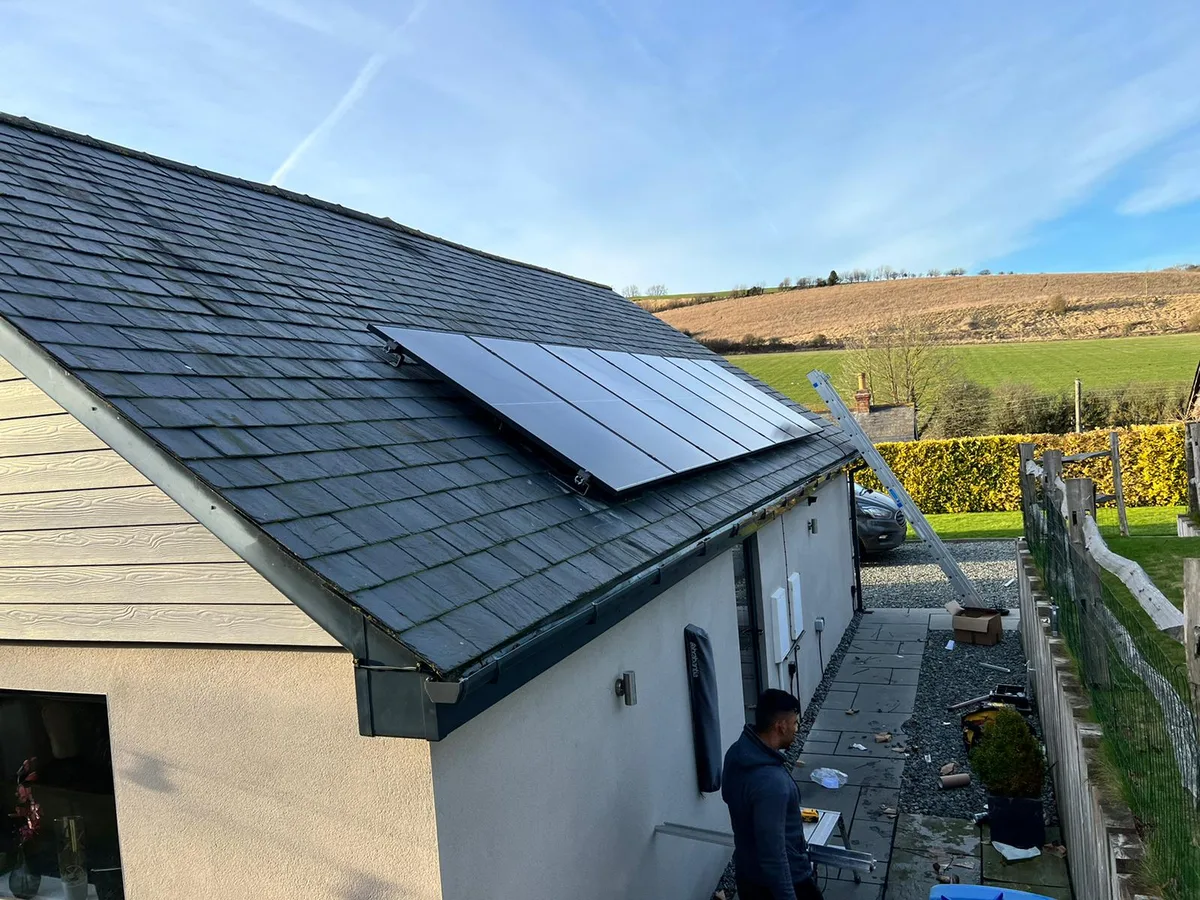 Installers fitting solar panels on a roof